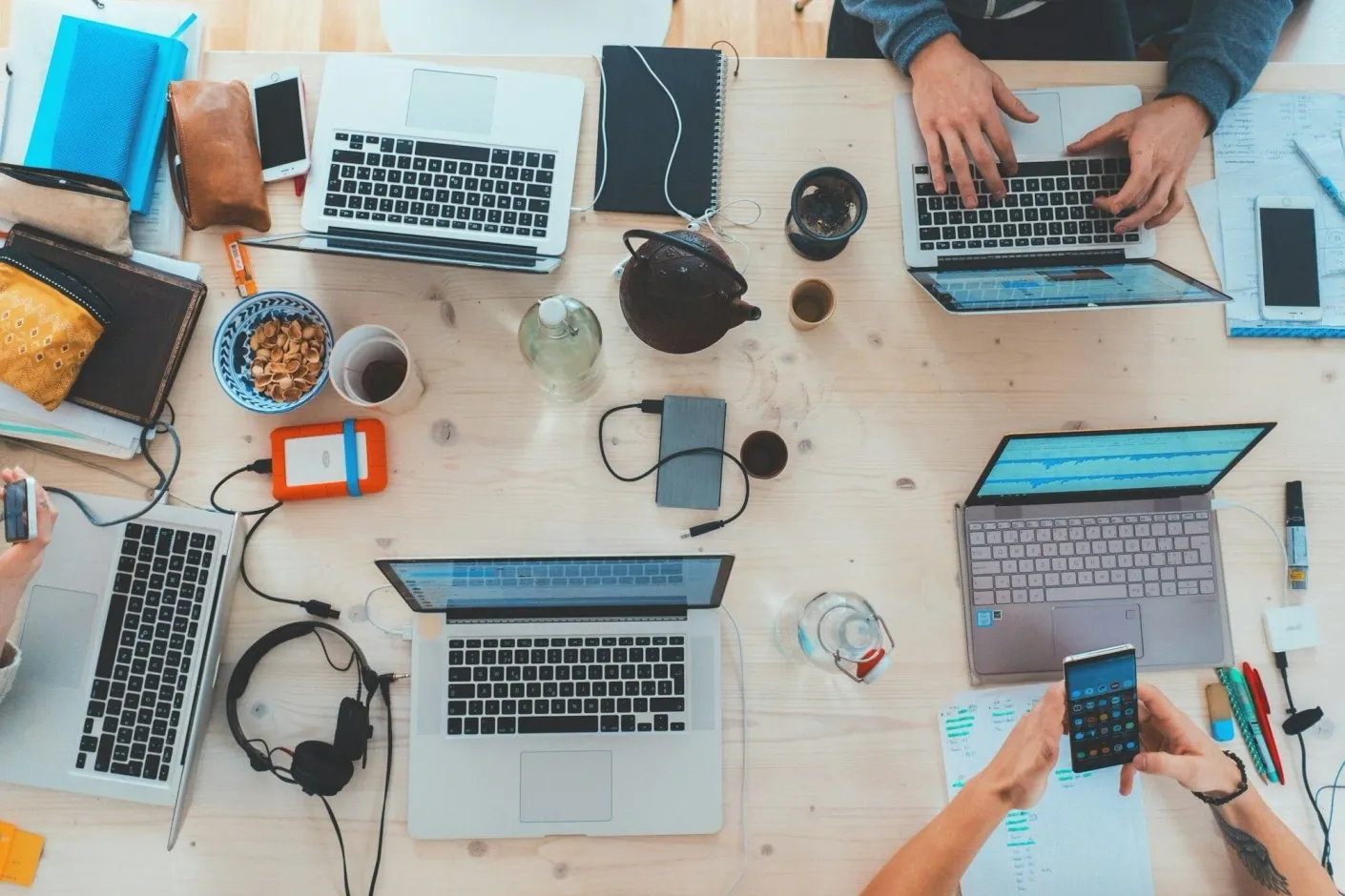 Overhead view of a team working on laptops around a shared table